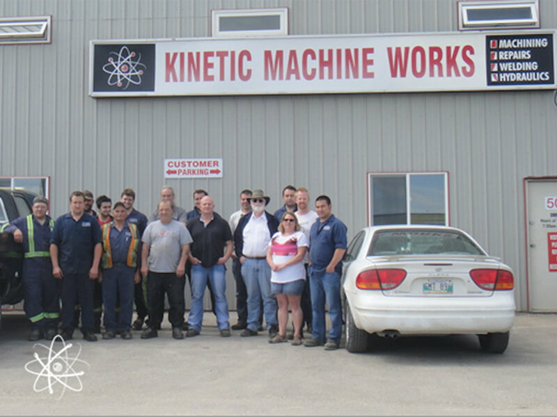 group photo of Kinetic Machine Works outside their building