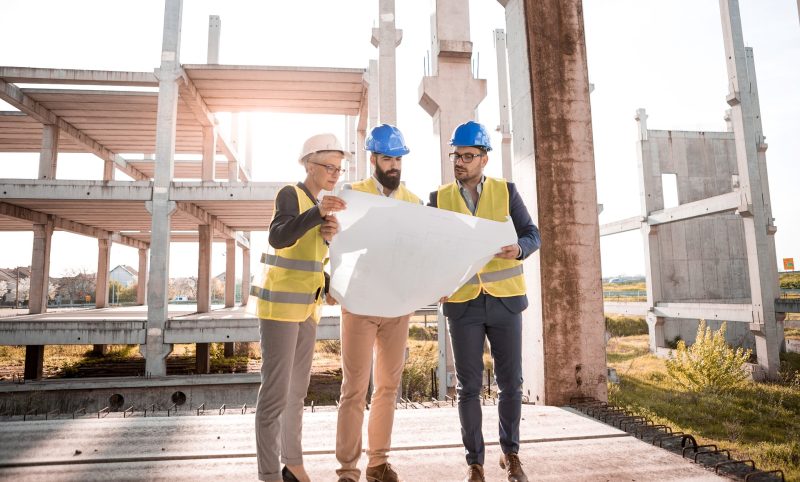 three people reviewing a plan at a construction site