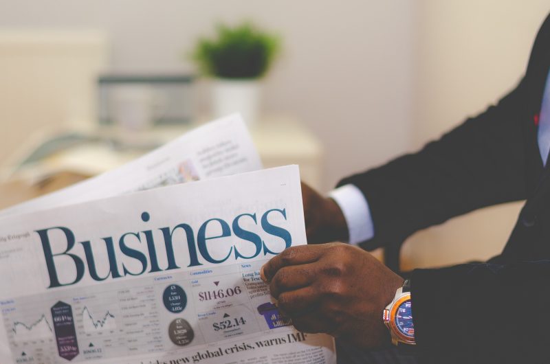 person reading the Business section of the newspaper