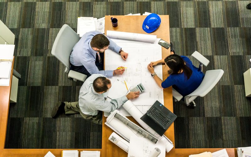 three people reviewing construction drawings