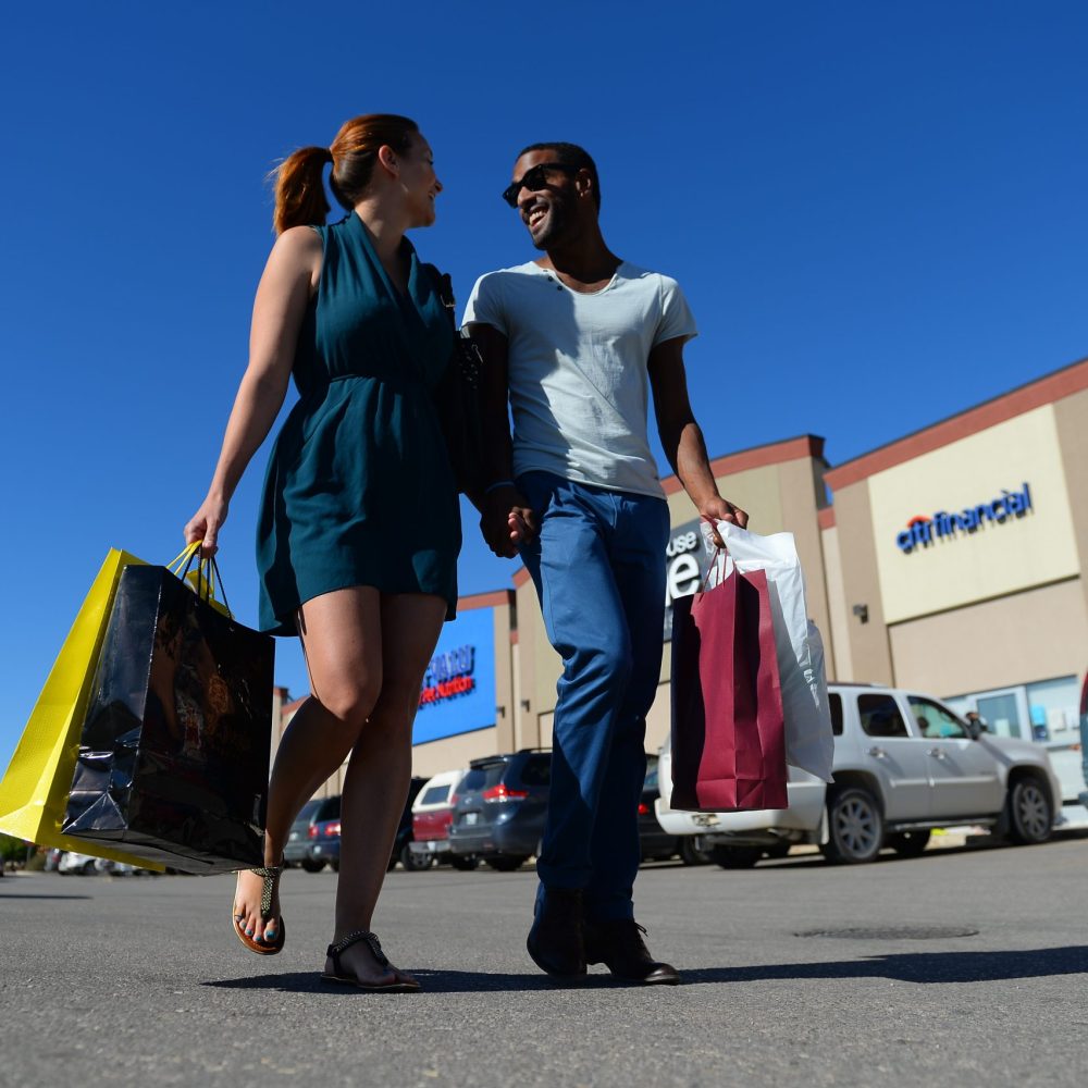 man and woman walking outside with shopping bags